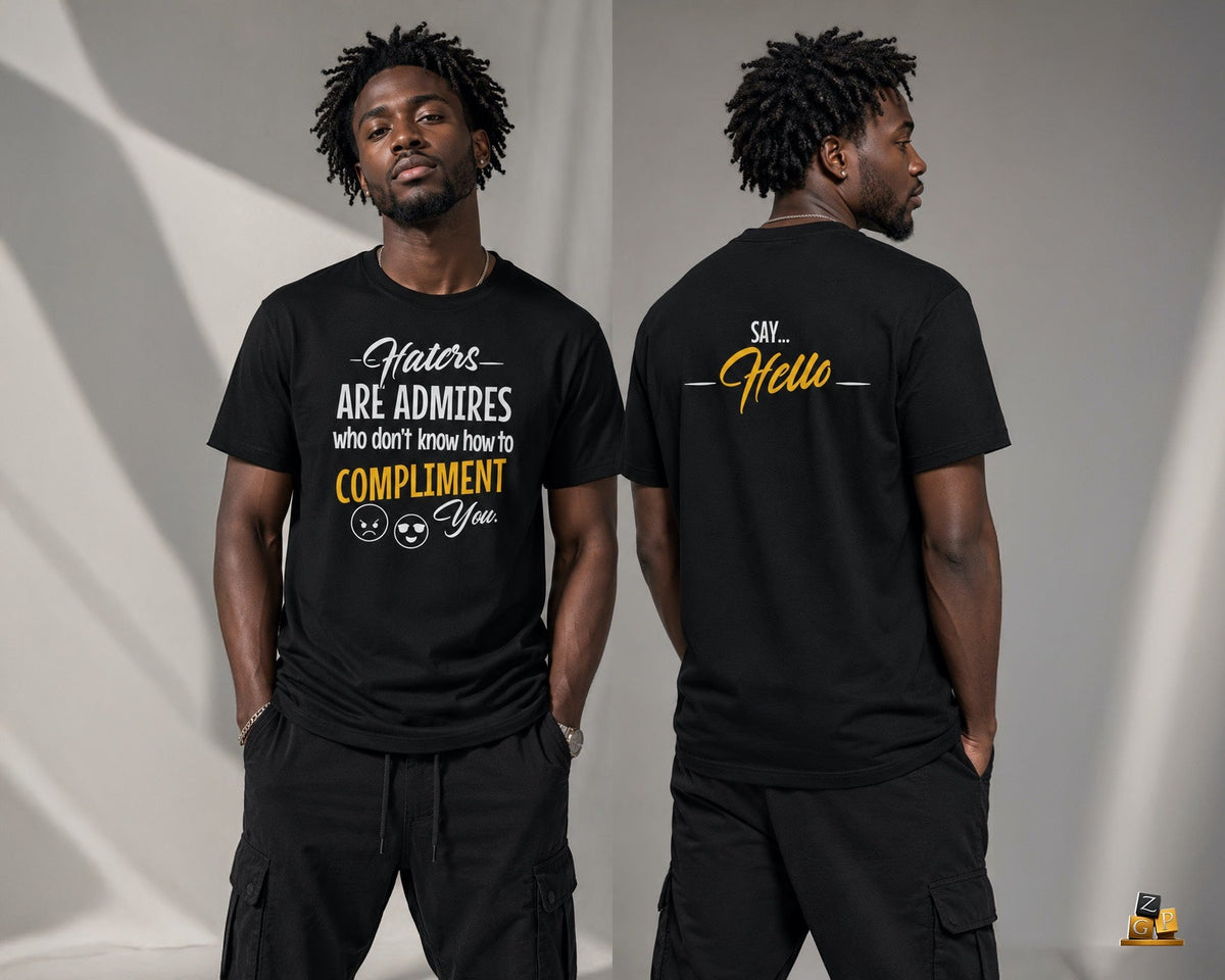 A man modeling a black graphic t-shirt, showing both the front and back views. The front of the shirt features white and yellow text that reads 'Haters ARE ADMIRERS who don't know how to COMPLIMENT You' with a smiley-face graphic.